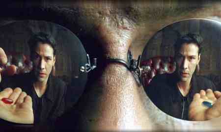 A still from The Matrix. A close-up of Morpheus' mirror sunglasses shows Keanu's reflection as he reaches for the red pill from the palm of one hand. In the other hand is the blue pill.