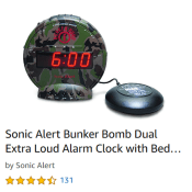 A circular digital alarm clock with camo pattern is shown with a Smartie shaped device meant to be inserted under the pillow to shake the person awake. The text reads 